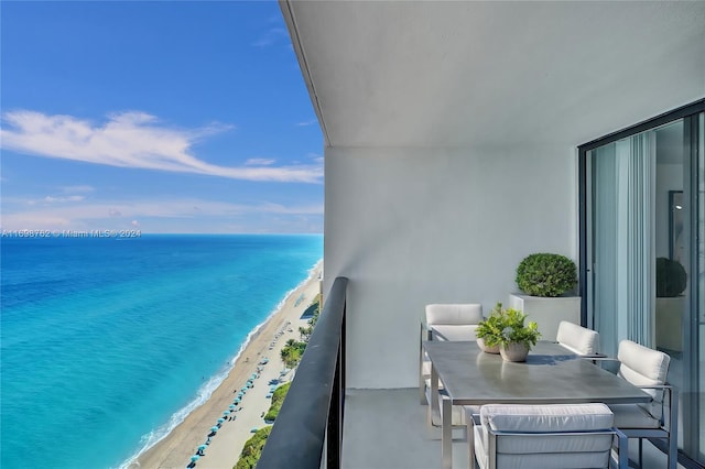 balcony with a water view and a beach view