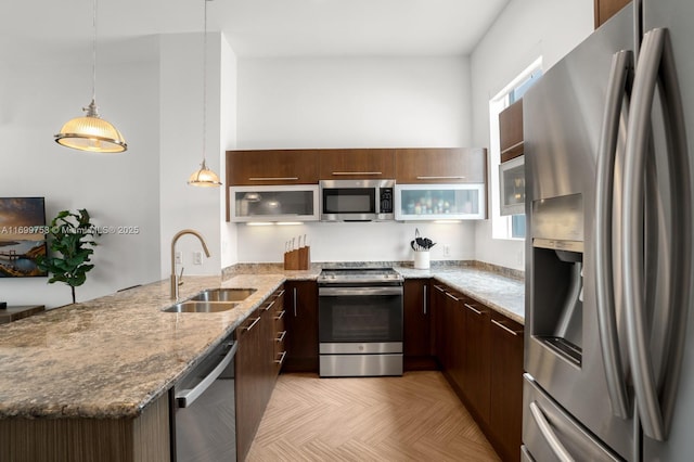 315 NE 7th St, Fort Lauderdale, FL 33304 - kitchen with stainless steel appliances, a sink, a peninsula, modern cabinets, and light stone counters