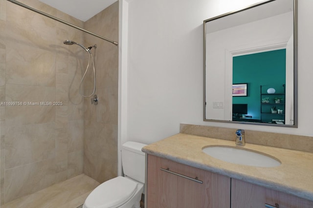 bathroom featuring vanity, toilet, and tiled shower