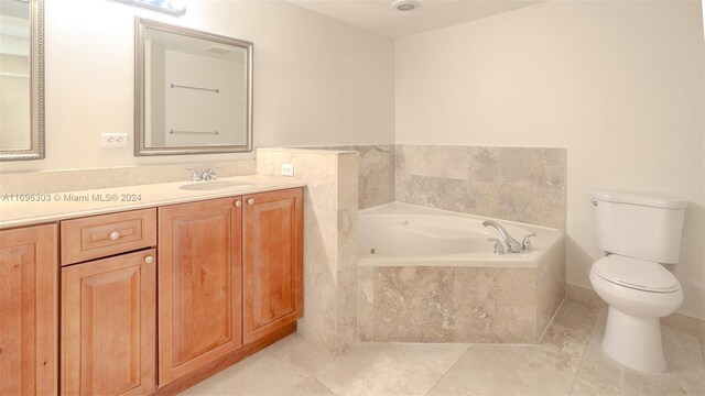 bathroom with tile patterned flooring, vanity, toilet, and tiled tub