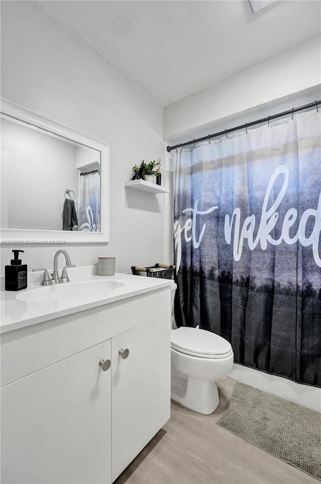 bathroom featuring wood-type flooring, vanity, and toilet