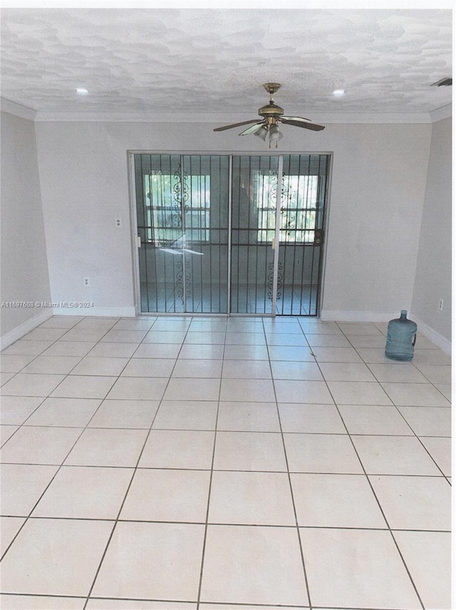 tiled spare room with crown molding, ceiling fan, and a textured ceiling