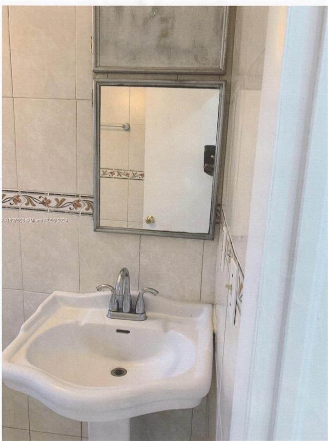 bathroom with tile walls and sink