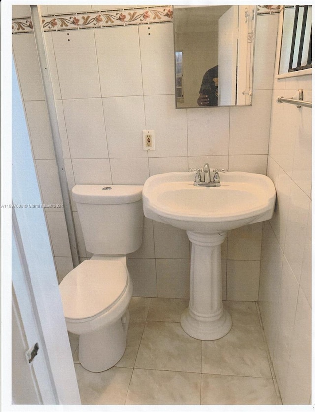 bathroom with tile patterned flooring, toilet, and tile walls