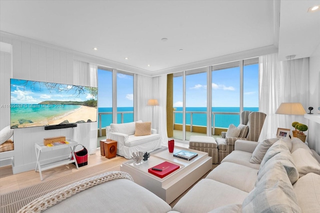 living room with hardwood / wood-style floors, floor to ceiling windows, and a water view