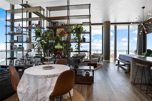 dining room featuring expansive windows, a water view, a chandelier, and dark wood-type flooring