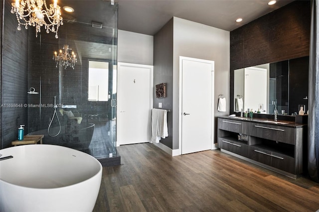 bathroom featuring vanity, plus walk in shower, hardwood / wood-style floors, and a notable chandelier