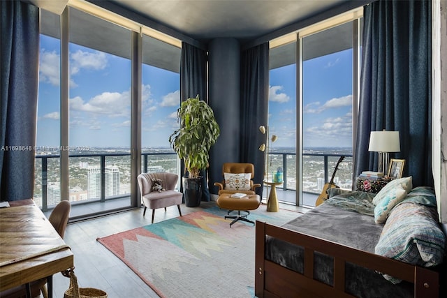 bedroom with multiple windows, expansive windows, and a water view