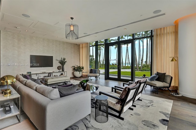 living room featuring expansive windows, hardwood / wood-style floors, and french doors