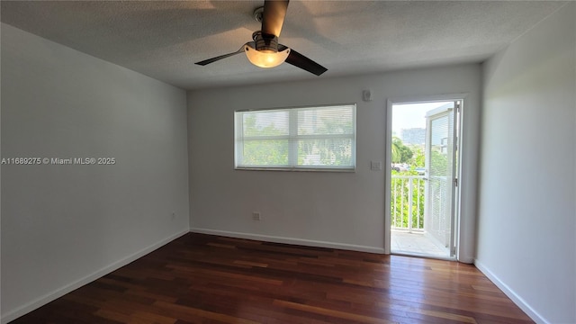 empty room with ceiling fan, dark hardwood / wood-style flooring, and a textured ceiling