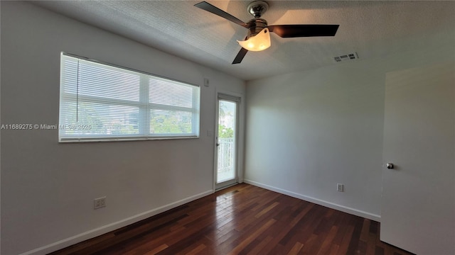 empty room with ceiling fan, dark hardwood / wood-style floors, and a textured ceiling