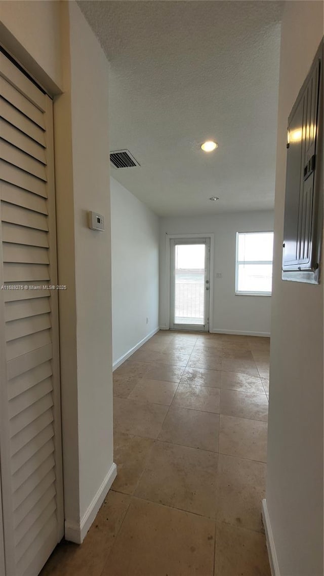 hallway with a textured ceiling