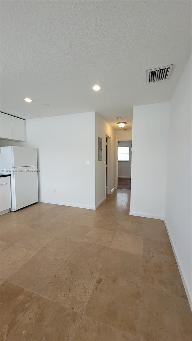 spare room featuring a textured ceiling and electric panel