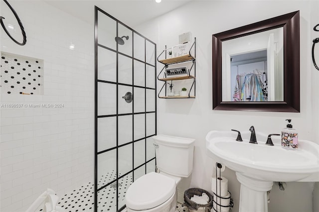 bathroom featuring a tile shower and toilet