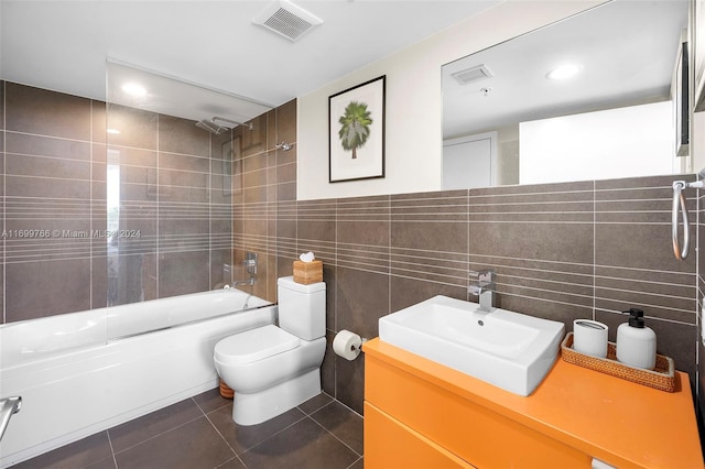 full bathroom featuring tile patterned flooring, toilet, shower / tub combination, vanity, and tile walls