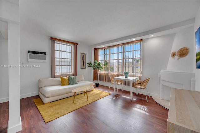 sitting room with hardwood / wood-style flooring and a wall mounted AC