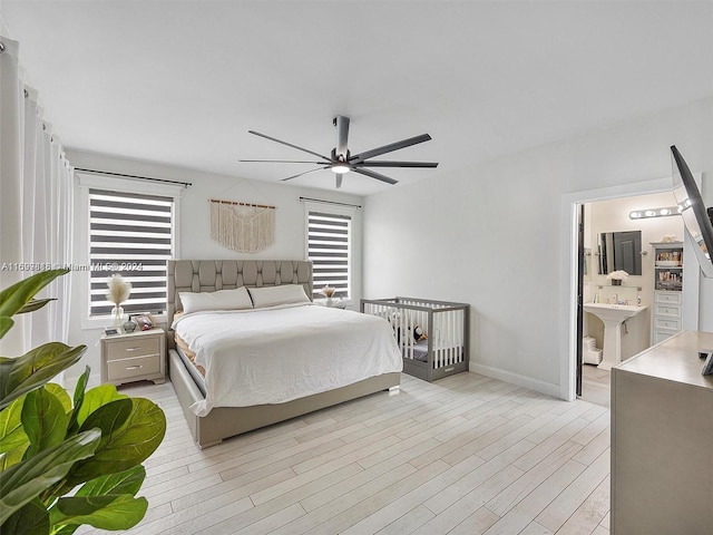 bedroom with ensuite bathroom, ceiling fan, light hardwood / wood-style floors, and sink