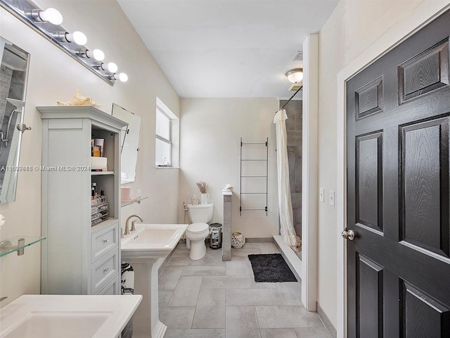 bathroom featuring tile patterned floors, curtained shower, sink, and toilet