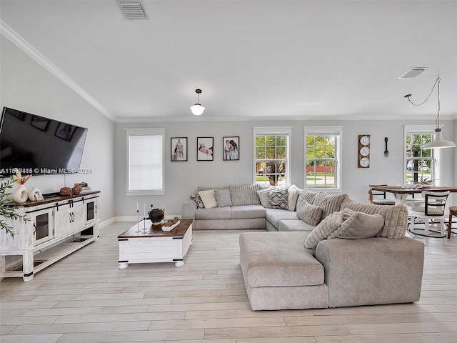 living room with light wood-type flooring, crown molding, and a wealth of natural light