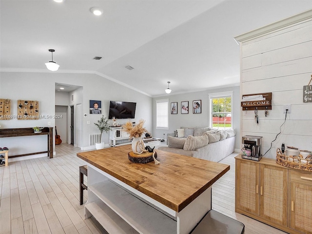 living room with light wood-type flooring, lofted ceiling, and crown molding