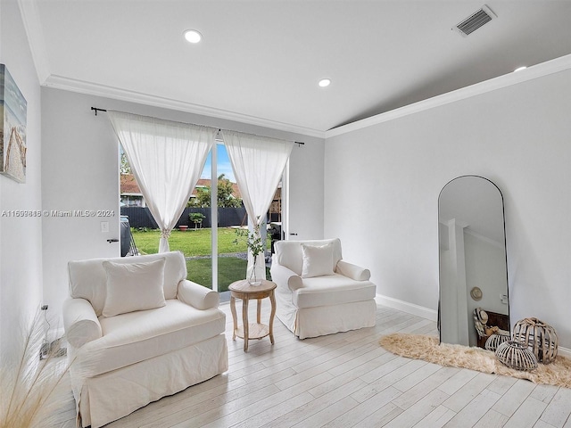 living room featuring light hardwood / wood-style floors and ornamental molding