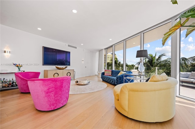 living room with hardwood / wood-style flooring and a wall of windows