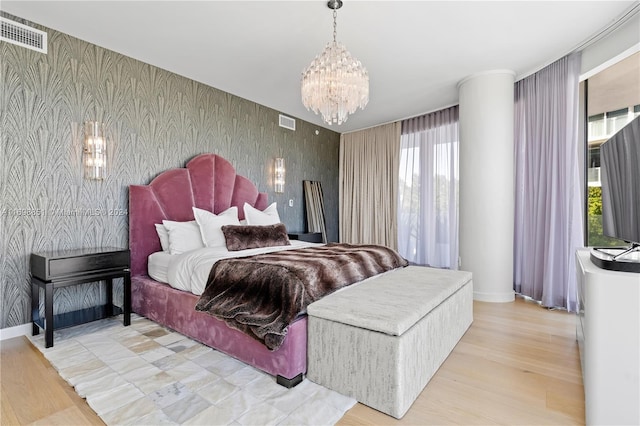 bedroom with a notable chandelier and light hardwood / wood-style floors