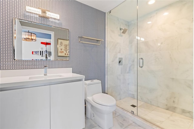 bathroom featuring vanity, toilet, and a shower with door