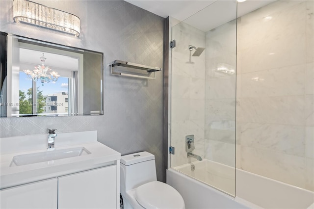 full bathroom featuring vanity, toilet, tiled shower / bath, and a notable chandelier