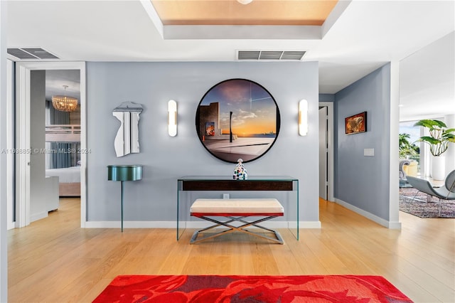 corridor featuring hardwood / wood-style floors and an inviting chandelier