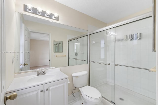 bathroom with an enclosed shower, vanity, toilet, and a textured ceiling