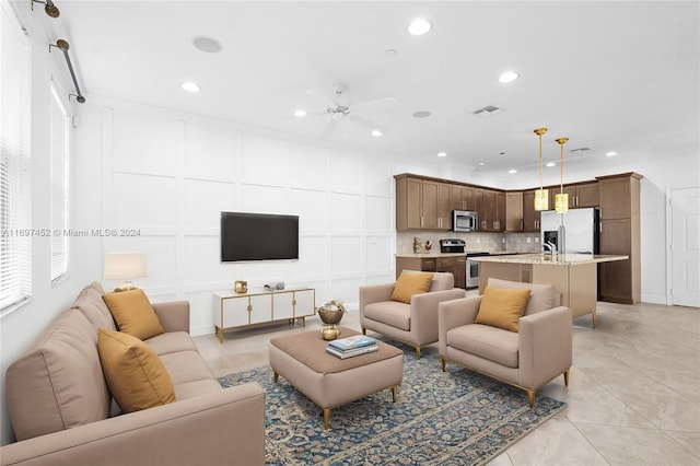 tiled living room with ceiling fan and sink