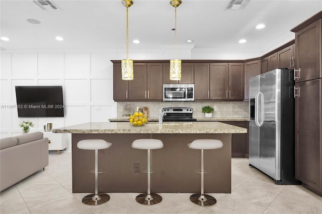 kitchen with dark brown cabinets, an island with sink, pendant lighting, and appliances with stainless steel finishes