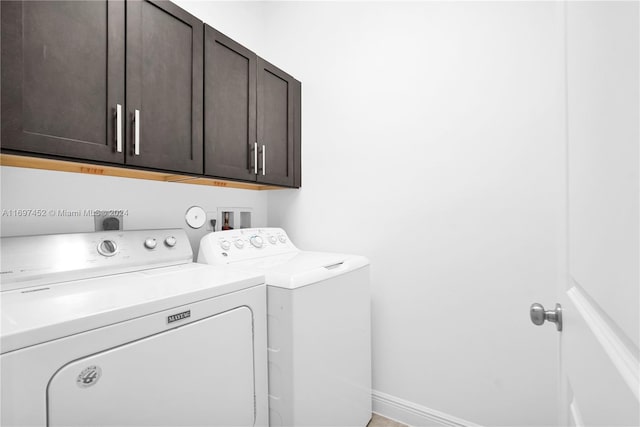 laundry room with washer and clothes dryer and cabinets