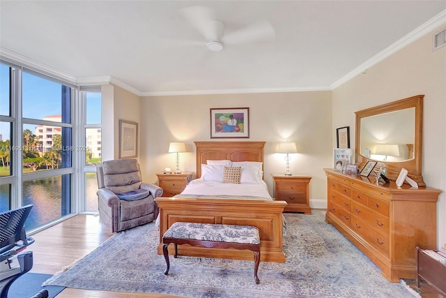 bedroom with crown molding, ceiling fan, and light hardwood / wood-style flooring