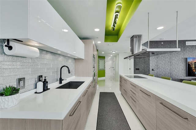 kitchen featuring white cabinets, black electric stovetop, light brown cabinets, and sink