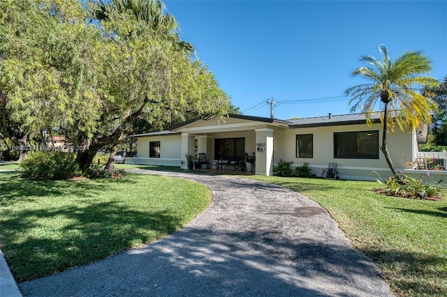 ranch-style house with covered porch and a front lawn