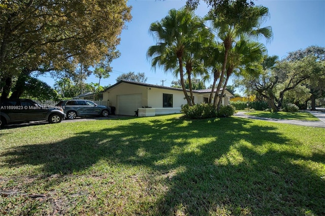 exterior space with a garage and a lawn