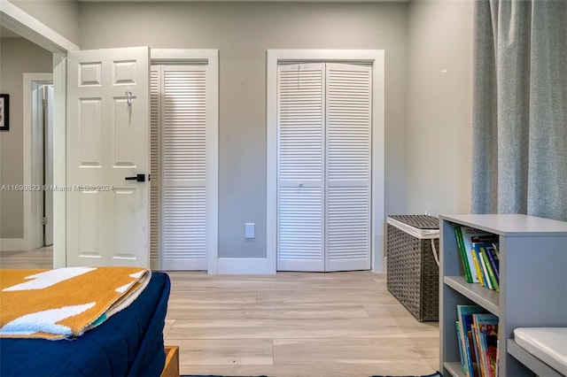 bedroom with light wood-type flooring and multiple closets