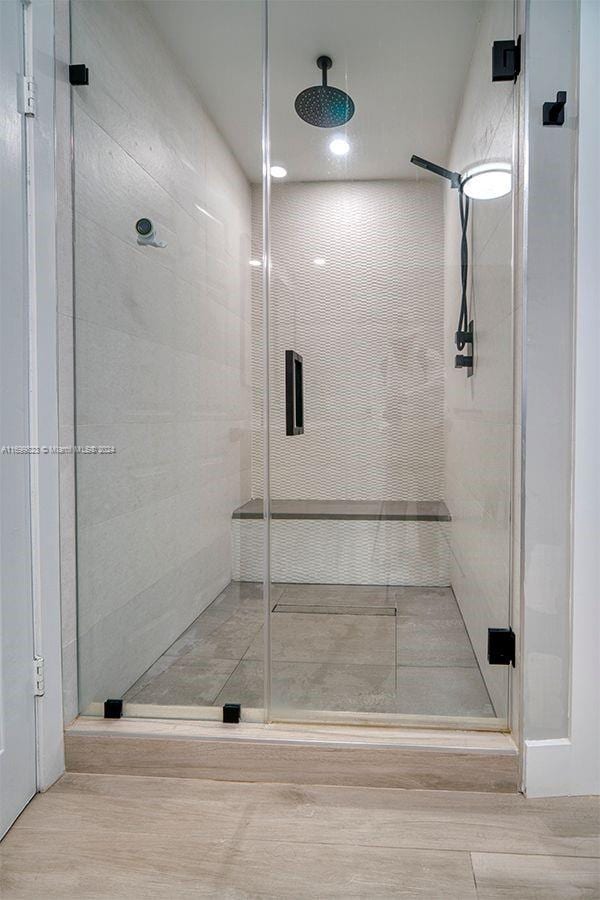 bathroom featuring hardwood / wood-style flooring and an enclosed shower