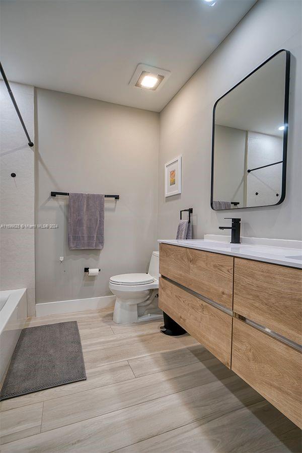 bathroom featuring hardwood / wood-style flooring, vanity, and toilet