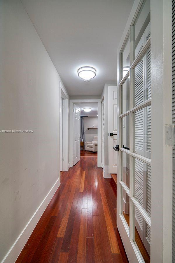 corridor with dark hardwood / wood-style flooring