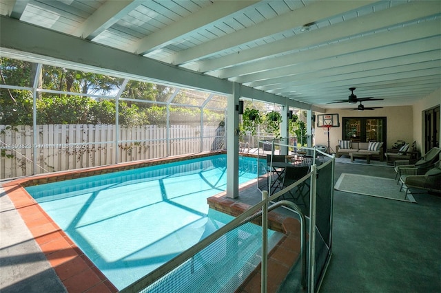 view of swimming pool with an outdoor hangout area, glass enclosure, a patio, and ceiling fan