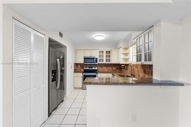 kitchen with backsplash, sink, kitchen peninsula, and stainless steel appliances