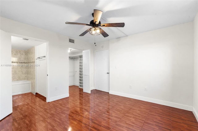 unfurnished bedroom featuring ensuite bath, ceiling fan, and hardwood / wood-style flooring