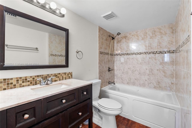 full bathroom with backsplash, toilet, hardwood / wood-style flooring, vanity, and tiled shower / bath