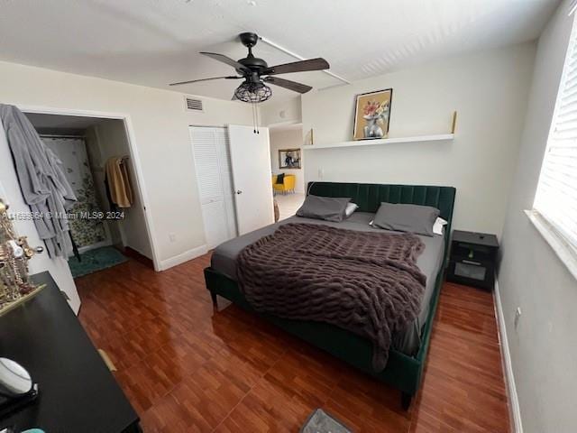 bedroom with a closet, ceiling fan, and dark hardwood / wood-style flooring