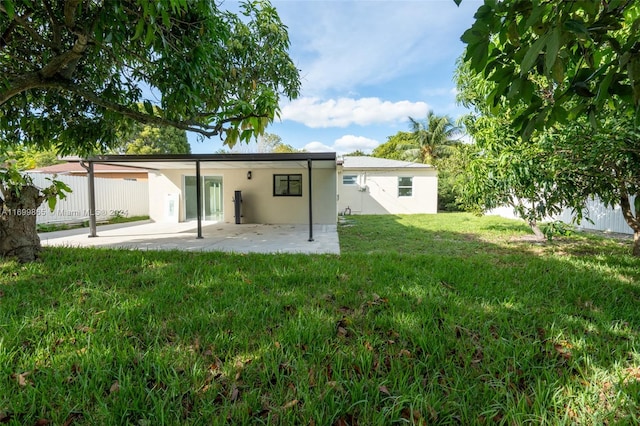 rear view of house featuring a patio area and a lawn