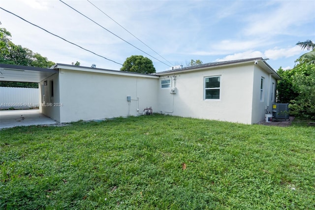 view of side of home with central air condition unit and a lawn