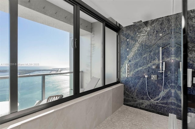 bathroom with tiled shower and a water view